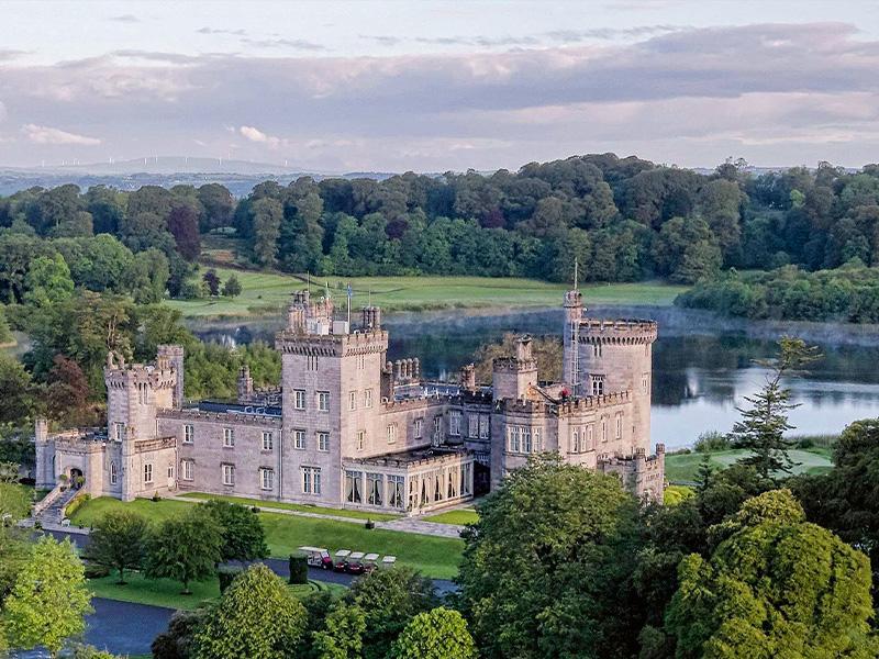 An aerial view of Dromoland Castle with the castle grounds and local forest behind.