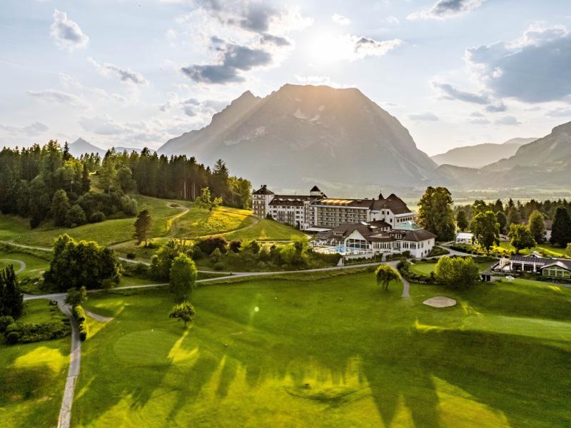 Exterior Aerial View with Golf Course at Forefront and Mountains in the Background