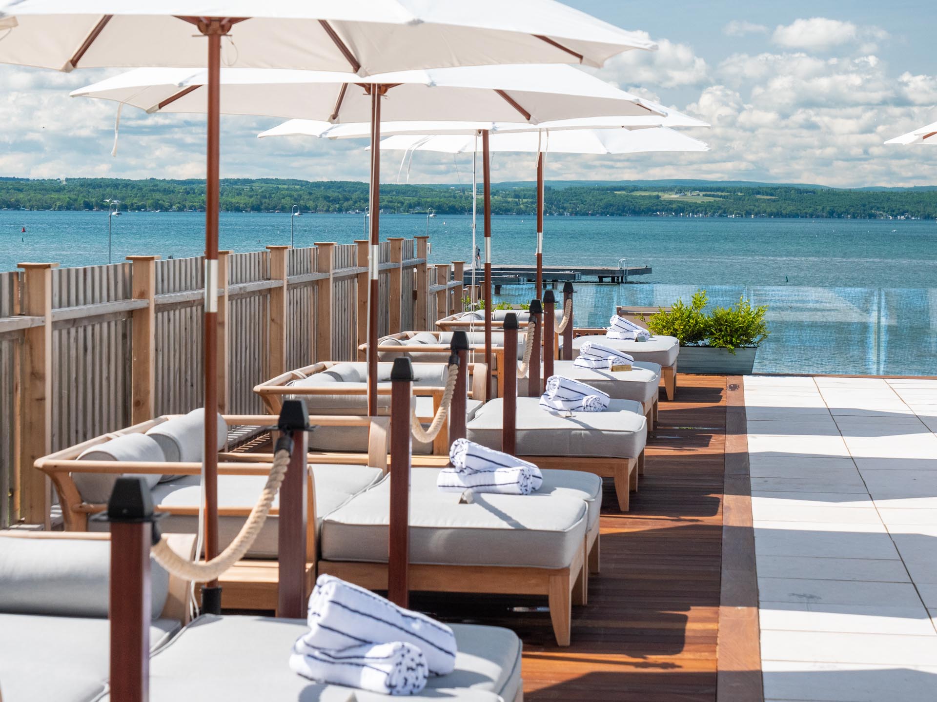 Sunbeds and umbrellas poolside with lakeviews