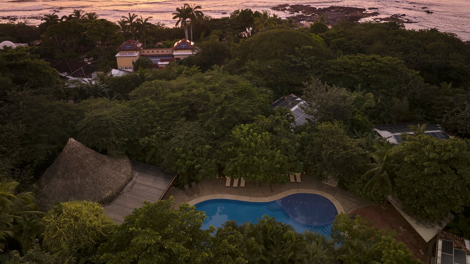 Aerial View of Pool and Hotel with Ocean in the Background