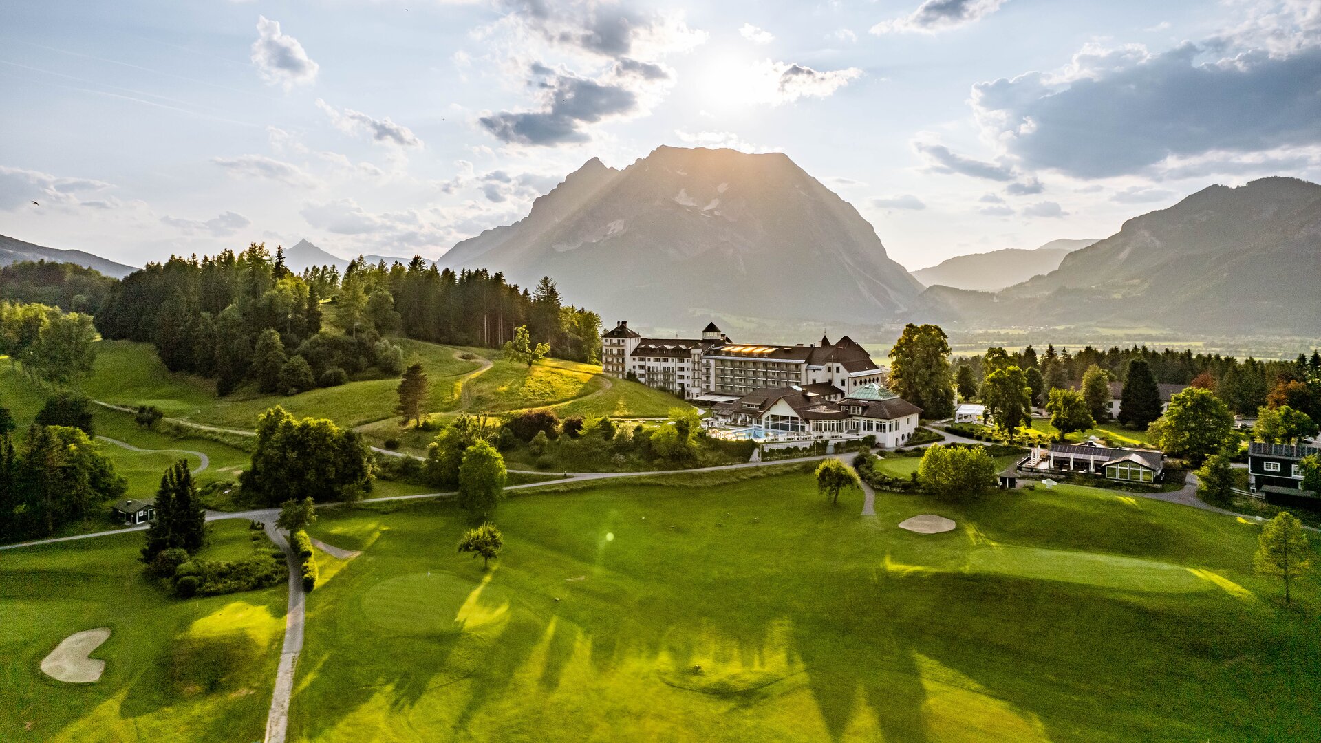 Exterior Aerial View with Golf Course at Forefront and Mountains in the Background