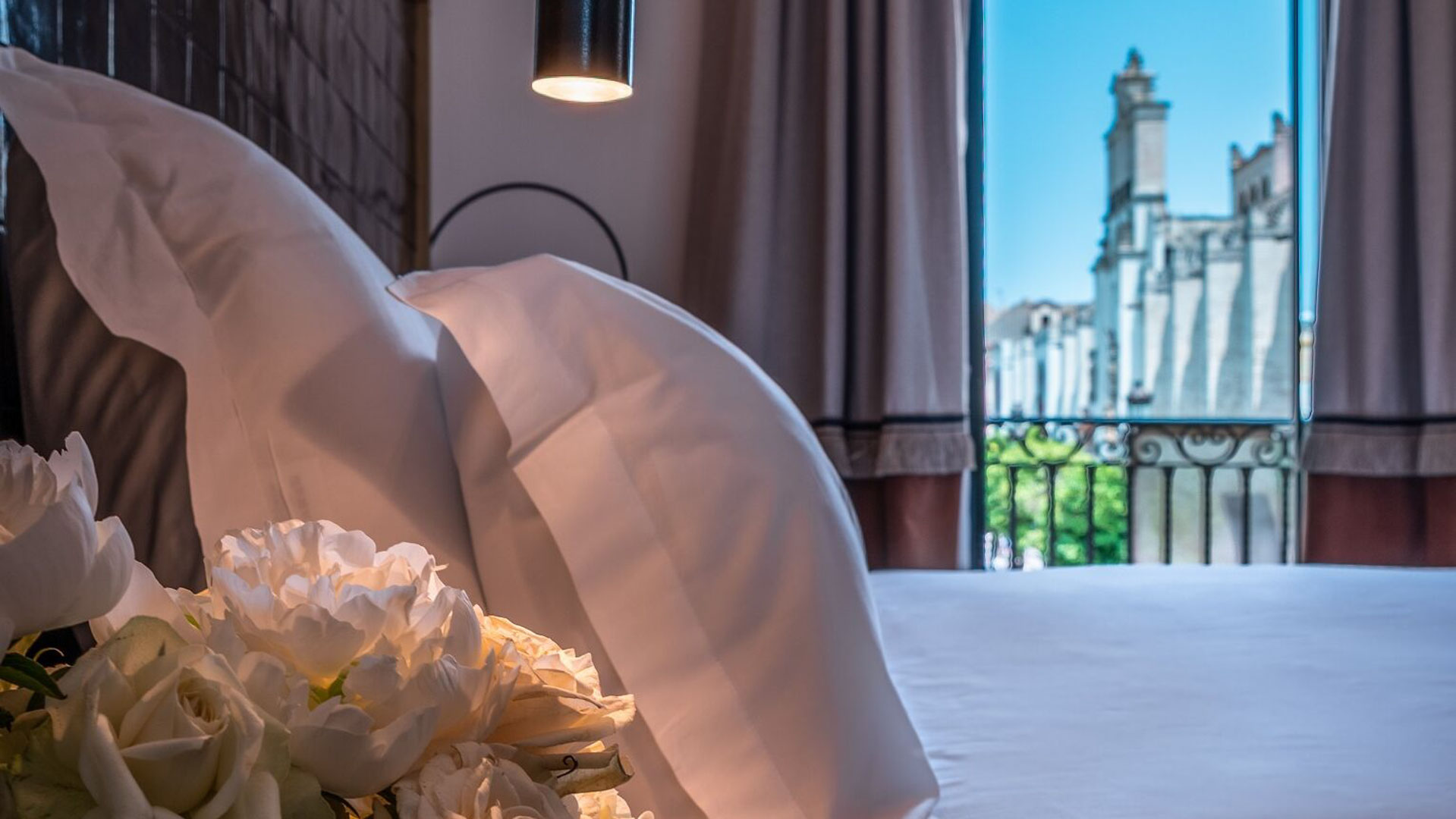 Guestroom Bed Detail with Flowers and Window View