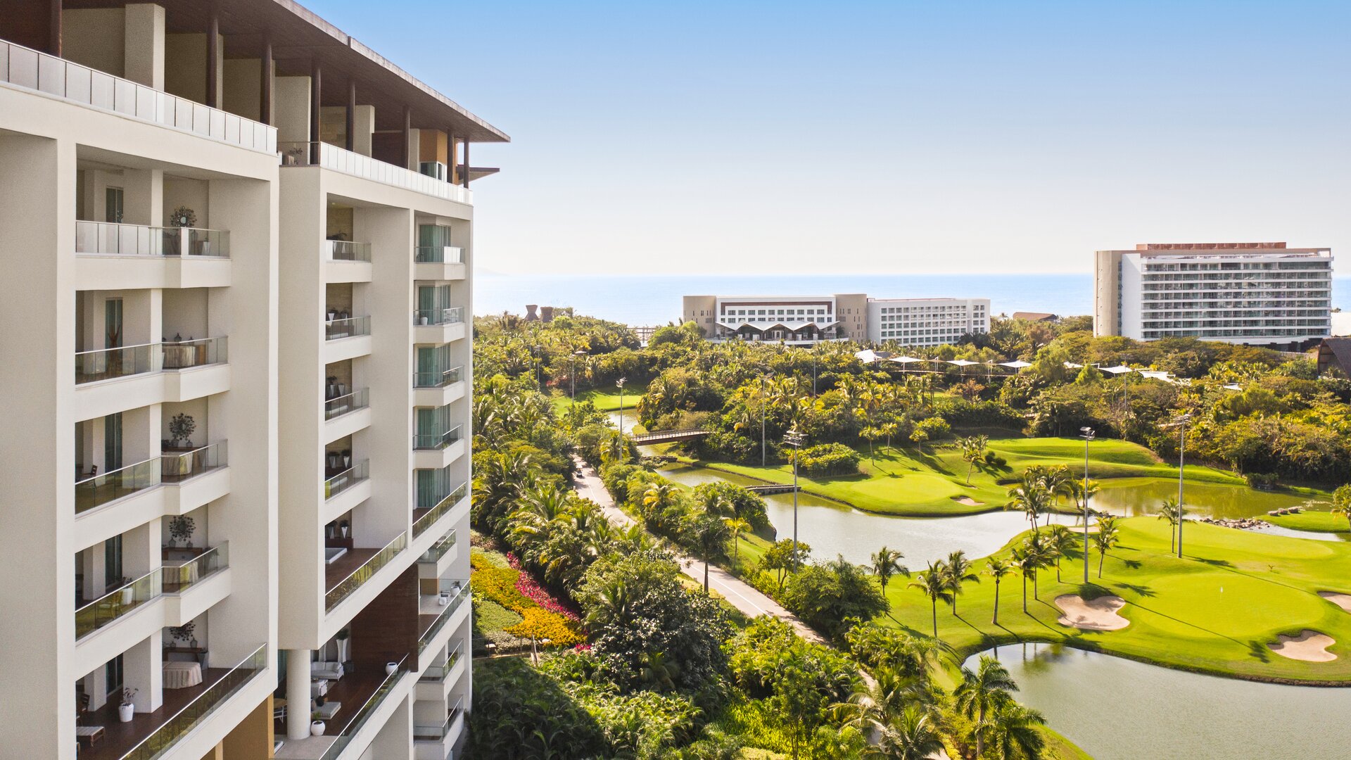 Facade View with Guestroom or Suite Balconies and Golf Course in the Background