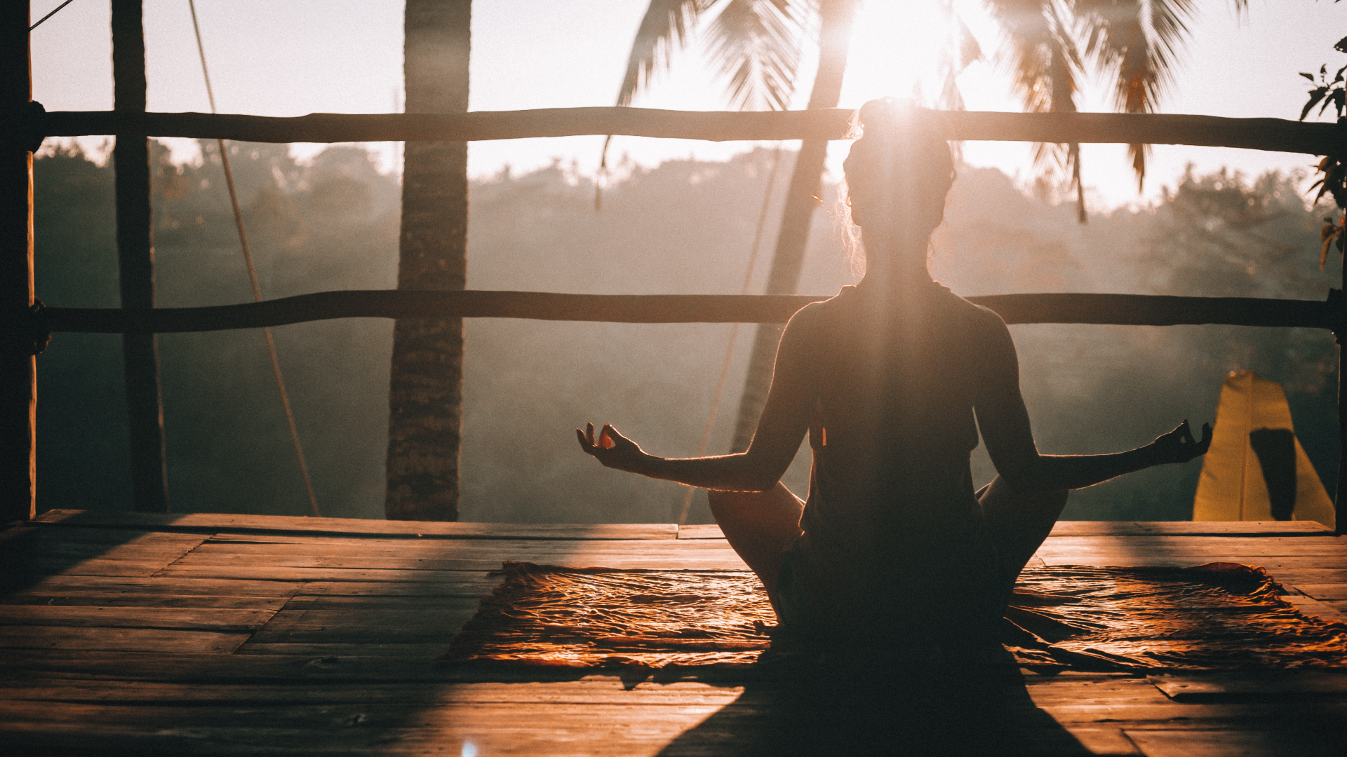 woman meditating in sunlight in front of window