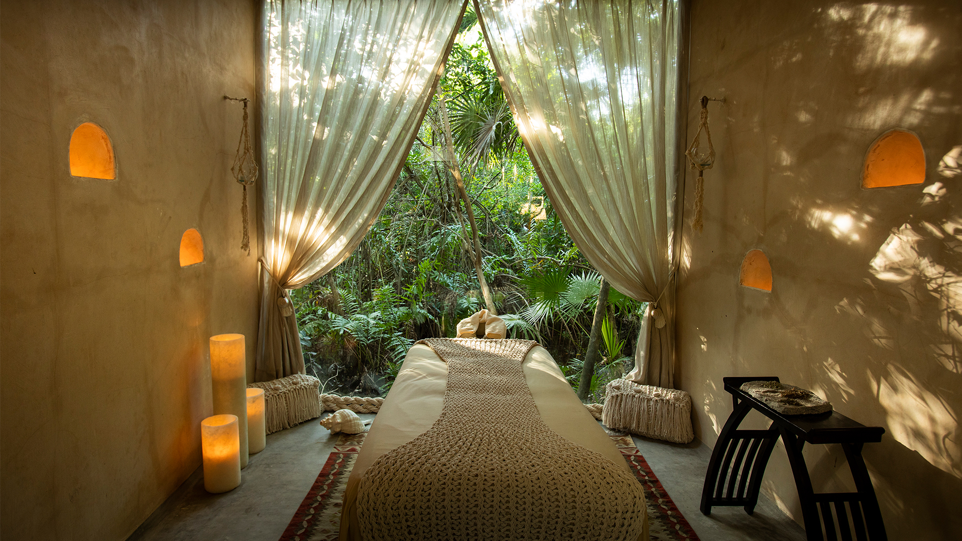 palmaia the house of aia spa in the jungle linen draped massage table in a pavilion with curtains pulled back to reveal a jungle exterior