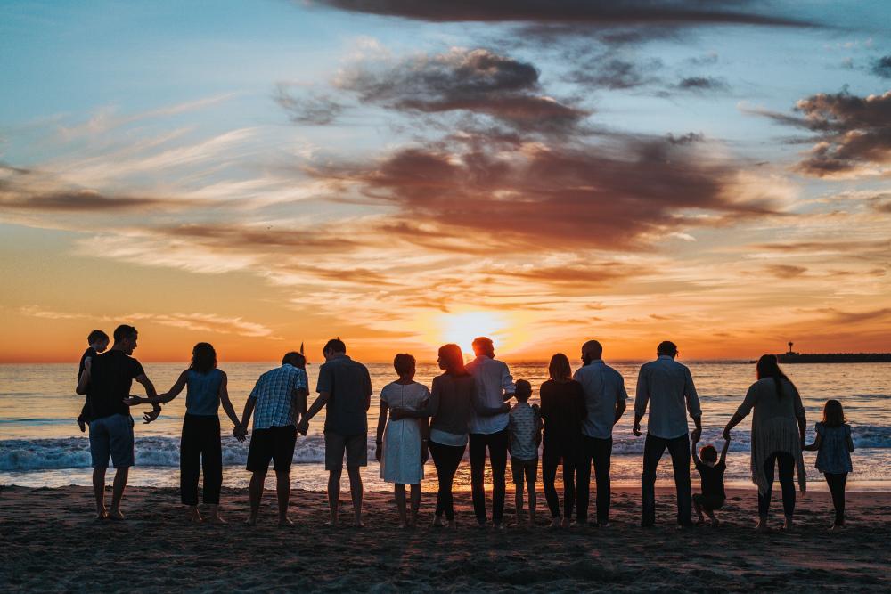 Family on beach at sunset, image by Tyler Nix via Unsplash