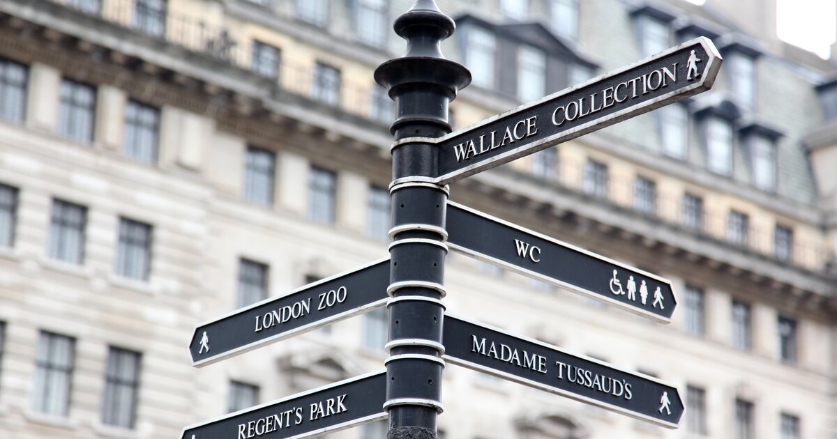 A picture of street signs in London, with directional arrows to the London Zoo, Wallace Collection, Regents Park and more