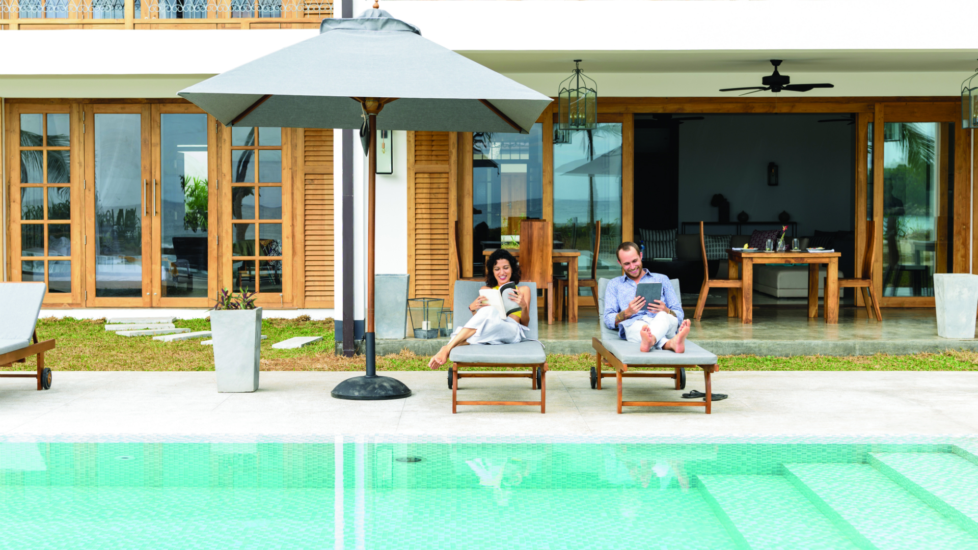 a couple lounging poolside in private preferred residence