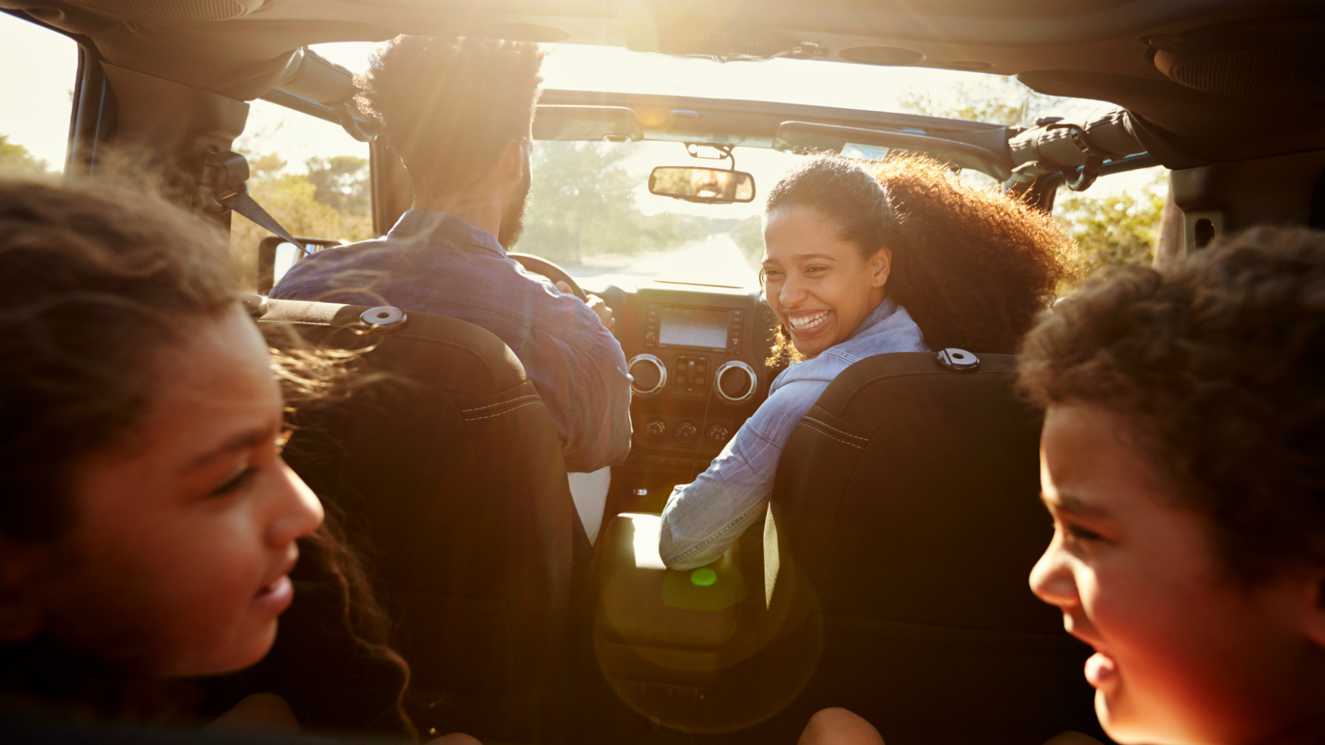 black family on road trip in suv smiling 