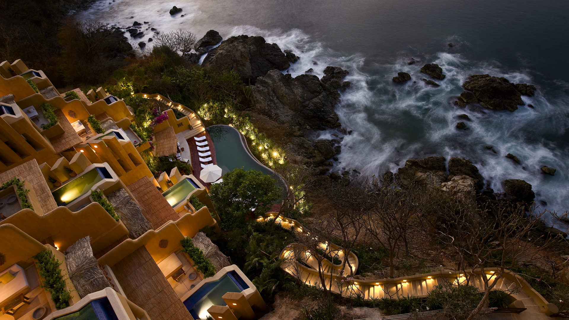 clifftop resort at night overlooking rocky ocean edge
