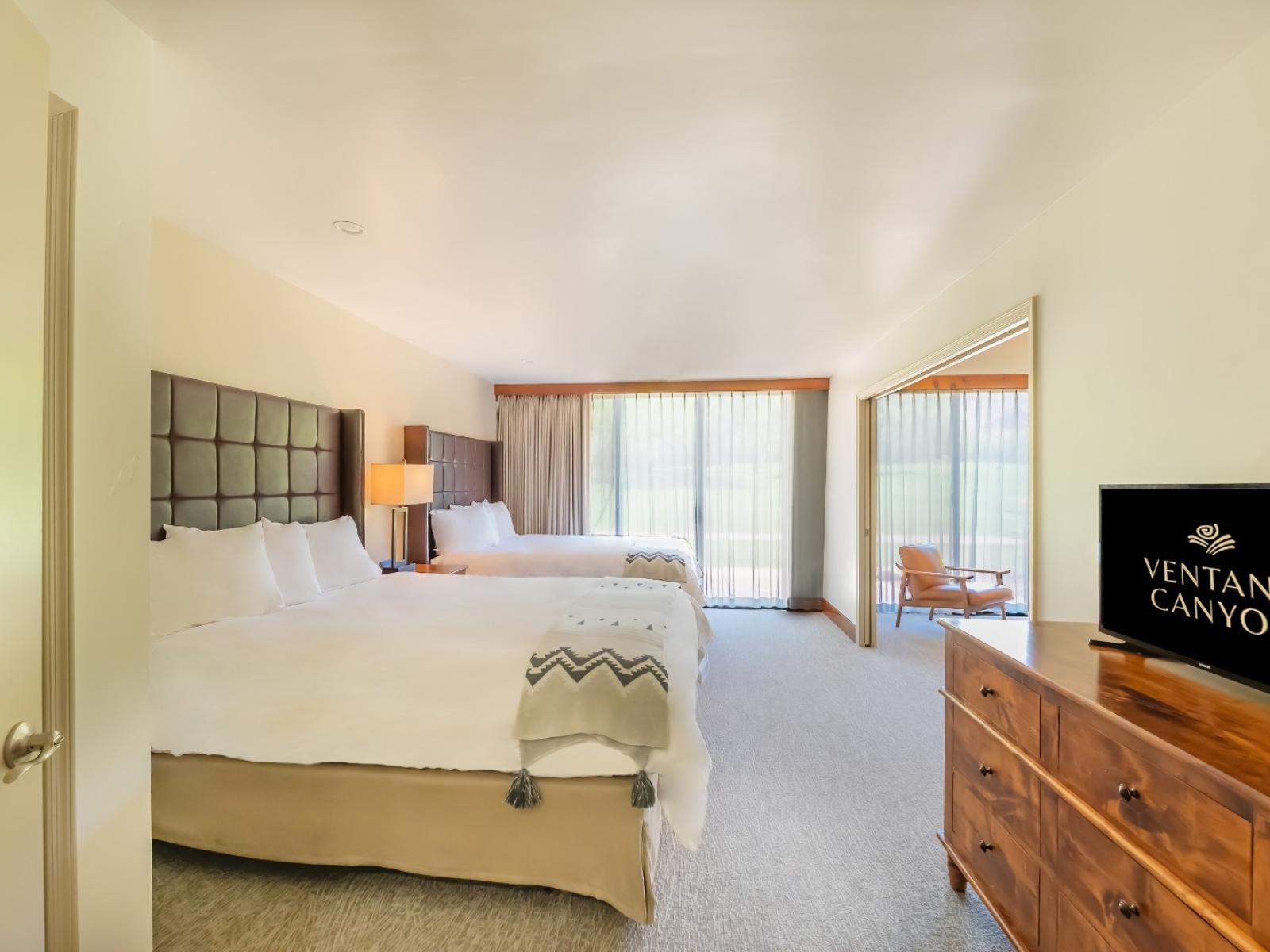 The bedroom from the Club Suite with two queen beds and windows to the balcony.