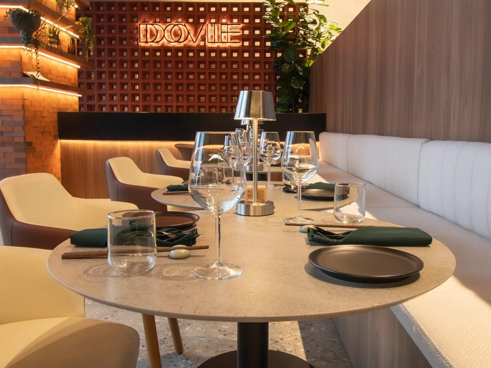 Dovle Branded Residences | Chic restaurant with elegant table settings, warm wood accents, and ambient lighting for a sophisticated dining experience.
