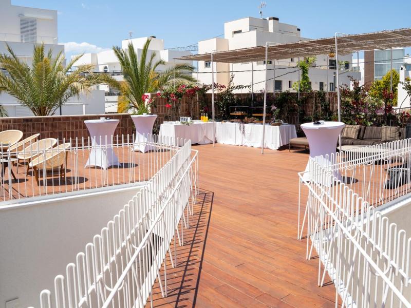 The Tagomago features a spacious open-air venue featuring elegant furnishings and vibrant greenery under sunny skies.