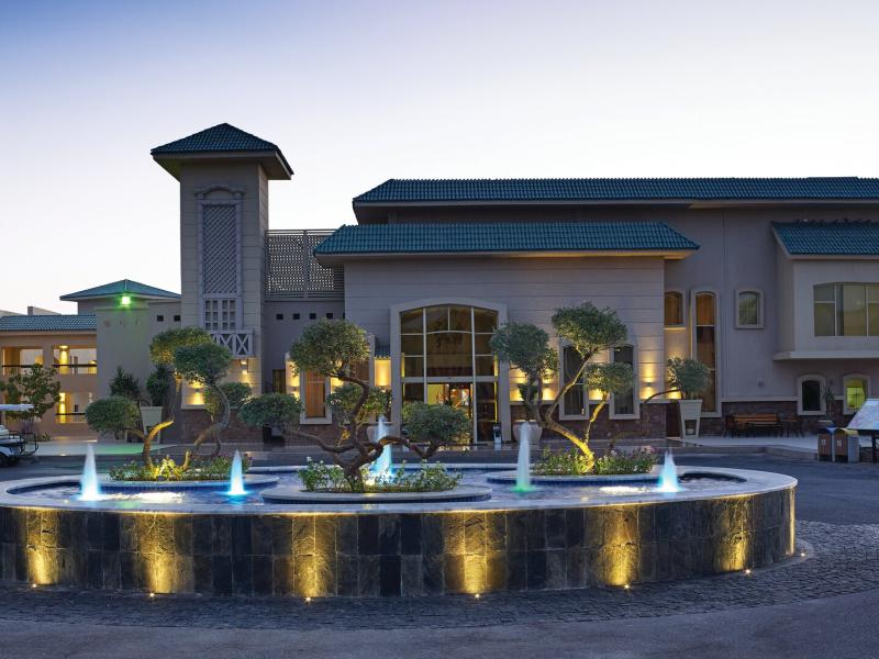 Coral Sea Holiday Village grand entrance featuring modern architecture and a beautifully lit fountain centerpiece.