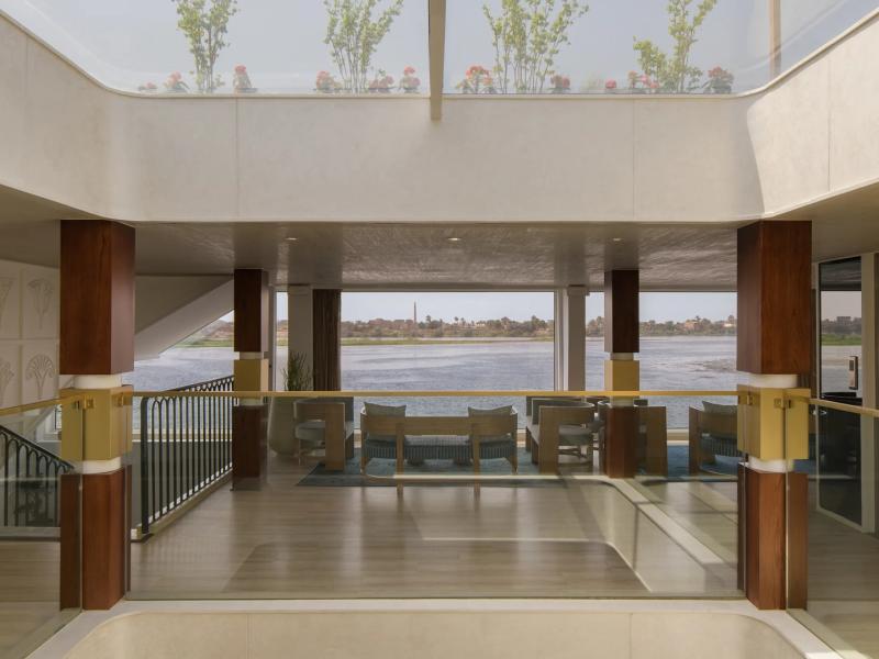 Experience a bright, open lobby with floor-to-ceiling views, natural light, and elegant wood and glass accents for a serene and stylish atmosphere.