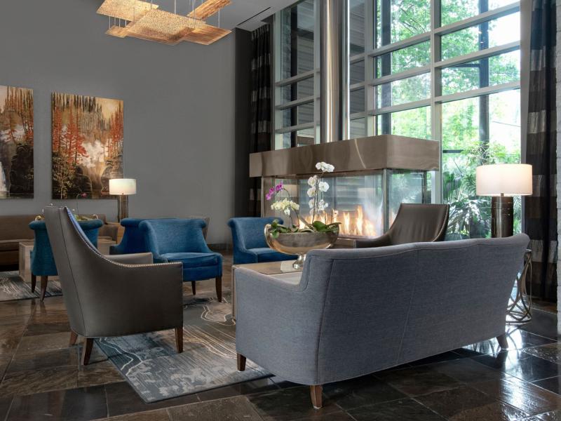 Sophisticated lobby with plush seating, a sleek fireplace, and expansive windows creating a bright and inviting atmosphere.