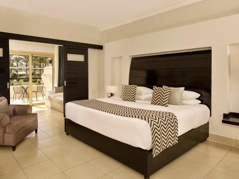 Roomy Family Suite Bedroom with a plush king bed, cozy seating, and a private balcony for outdoor enjoyment.
