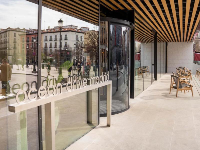 Stylish entrance with glass details and an inviting terrace overlooking the vibrant Plaza de Oriente.