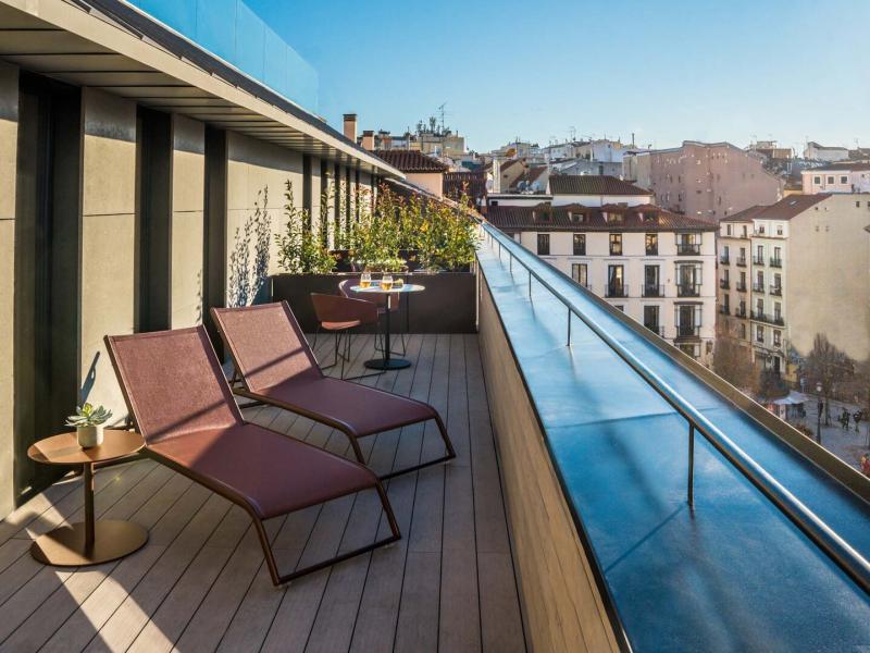 Corner Deluxe Terrace Guestroom spacious terrace with chic loungers and panoramic city views, perfect for relaxing under the sun.