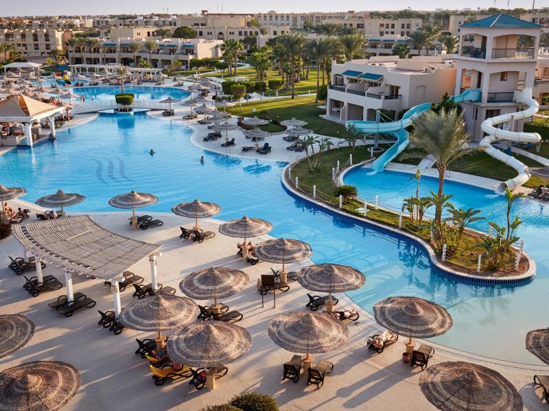 Overview of Coral Sea Holiday Village tropical oasis featuring expansive pools, winding slides, and sun-kissed relaxation spots.