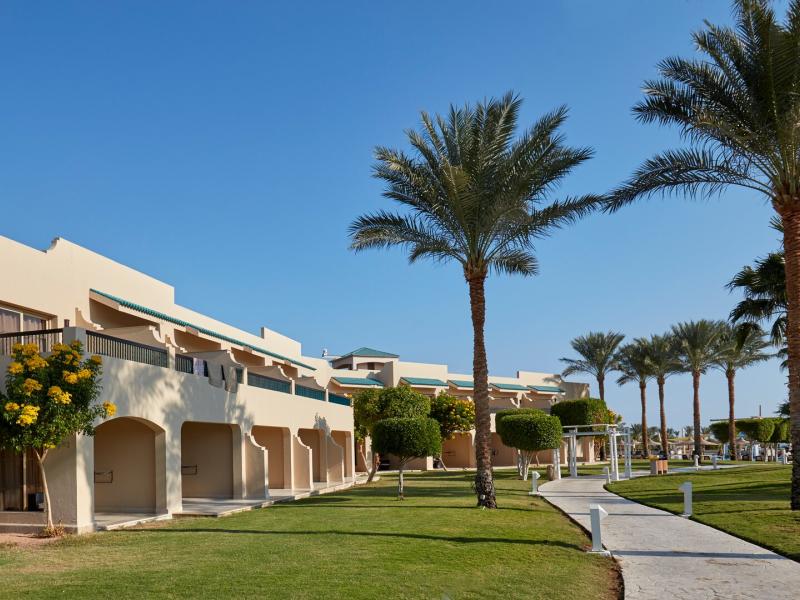 Landscaped gardens and elegant Mediterranean-style suite exteriors.