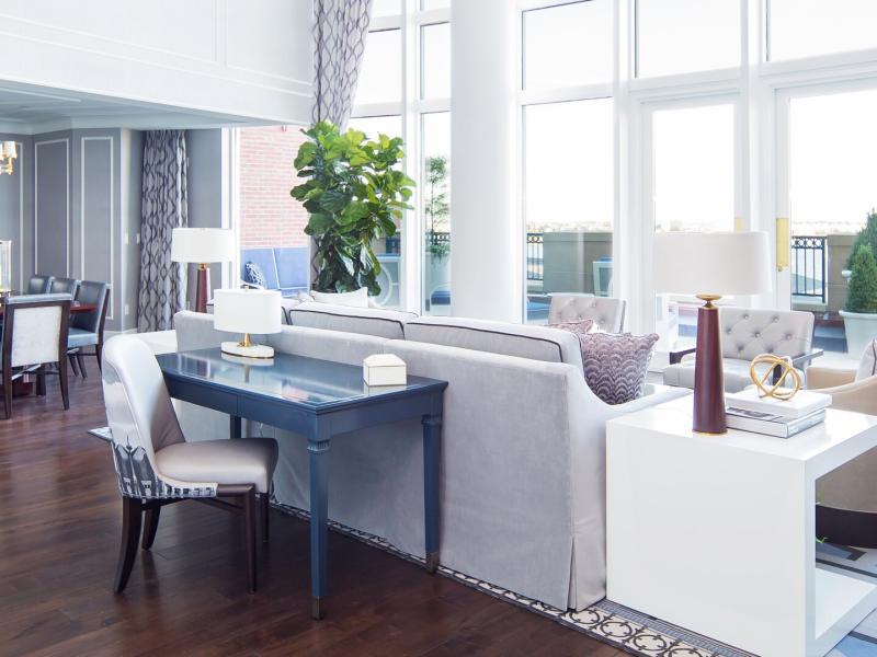 John Adams Presidential Suite bright, open living space featuring floor-to-ceiling windows and elegant hardwood floors, accented by soft gray furnishings and deep navy details.
