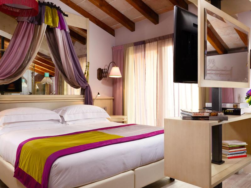 A Junior Suite with bold purple and lime accents energize this airy room with a modern canopy, mirrored details, and natural wood textures for a vibrant yet sophisticated ambiance.