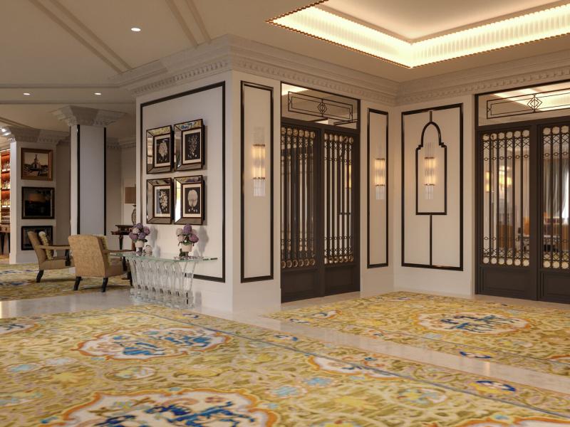 Luxurious lobby of Gran Hotel Claridge Granada with ornate wall paneling, black-framed glass doors, and a richly patterned carpet in golden yellow and teal accents.