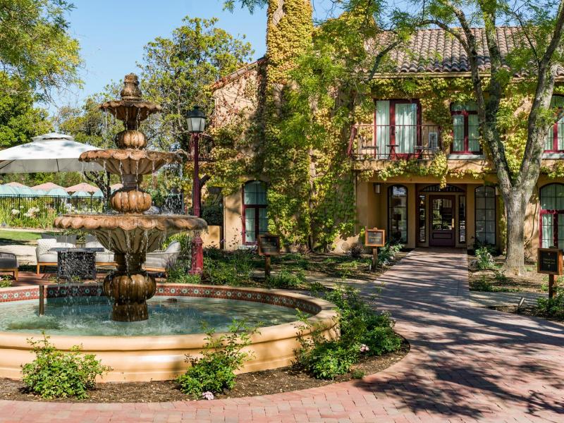 Vinarosa Resort & Spa charming front courtyard showcases a tiered stone fountain and ivy‑clad resort architecture accented with warm terracotta and soft green tones.