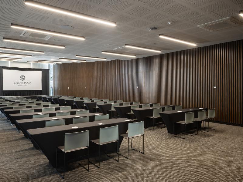 Conference room set in classroom style with desks and presentation screen at Galeria Plaza Monterrey.