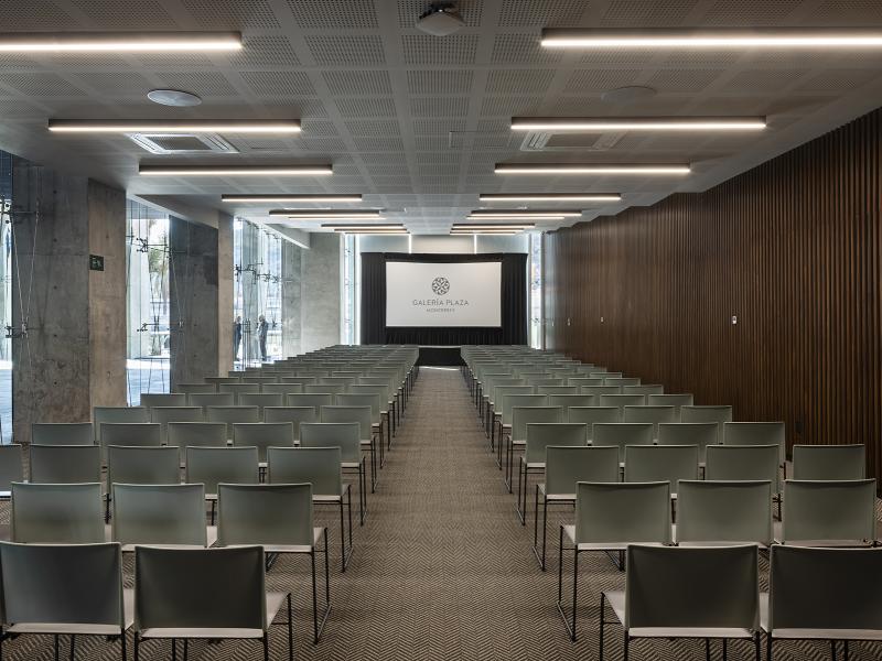 Conference room set in theater style with rows of chairs and presentation screen at Galeria Plaza Monterrey.