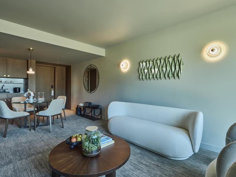 Rooftop suite living and dining area with sofa, round table, and kitchenette at Altis Porto Hotel