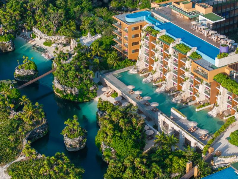 An ultra-refined retreat, Hotel Xcaret Arte with it’s cascading teal infinity pools, sculptural ivory stone facades, and verdant tropical foliage accented by soft coral and champagne tones.