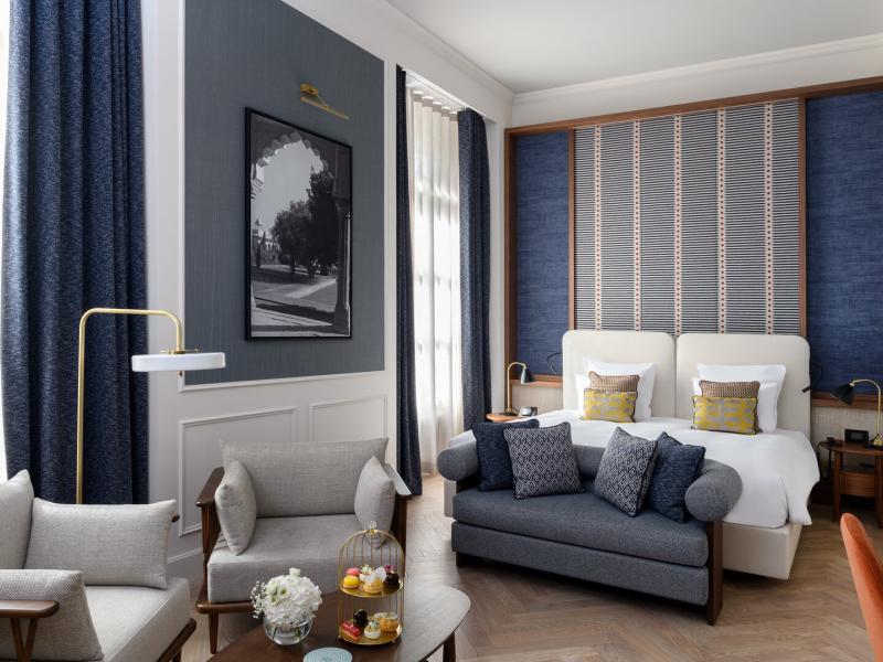 Traveller Junior Suite showcasing an elegant living space, twin bedding, and thoughtfully designed interiors inspired by Geneva’s contemporary art of living.