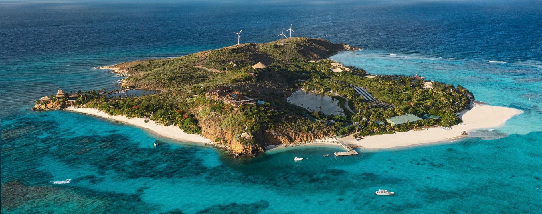 Aerial view of Necker Island, Richard Branson’s private Caribbean island in the British Virgin Islands, featuring turquoise waters, white sand beaches, and luxury villas surrounded by tropical greenery.