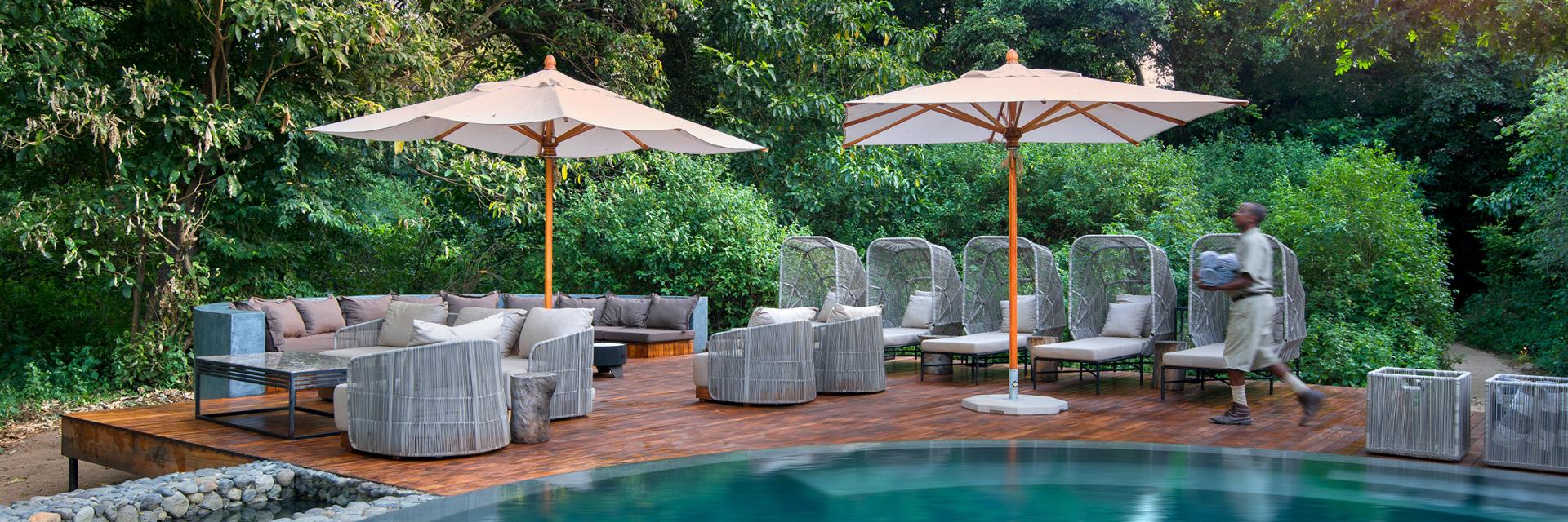 andBeyond Lake Manyara Tree Lodge Pool with loungers and umbrellas.